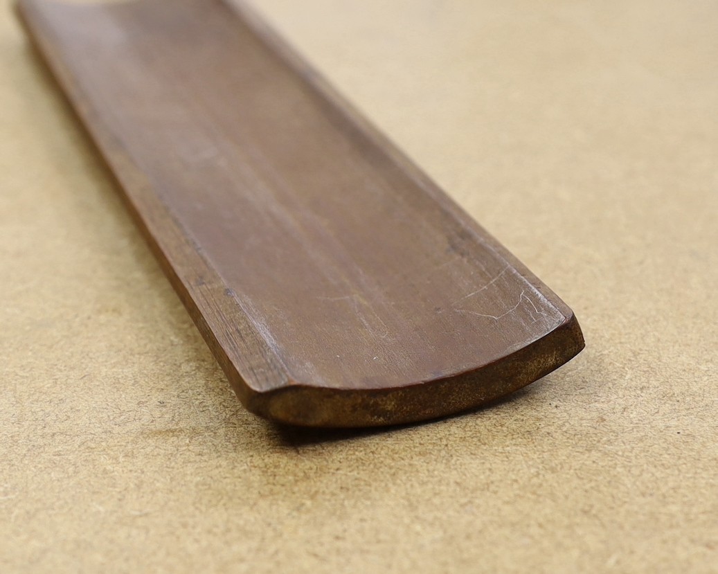 A Chinese bamboo inscribed wrist rest, carved in relief with columns of calligraphy, 30cm wide